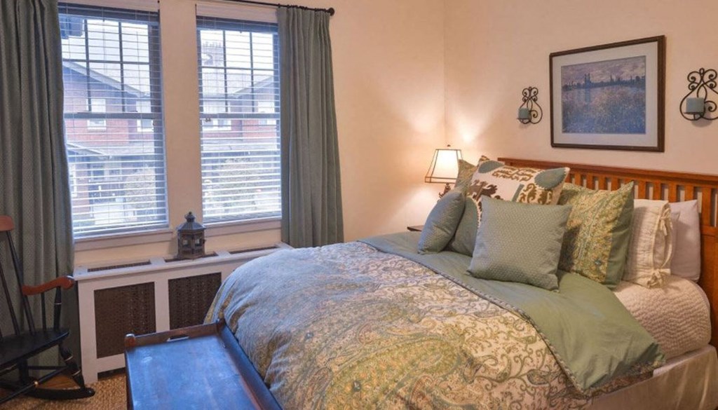 a bedroom with a bed and two windows