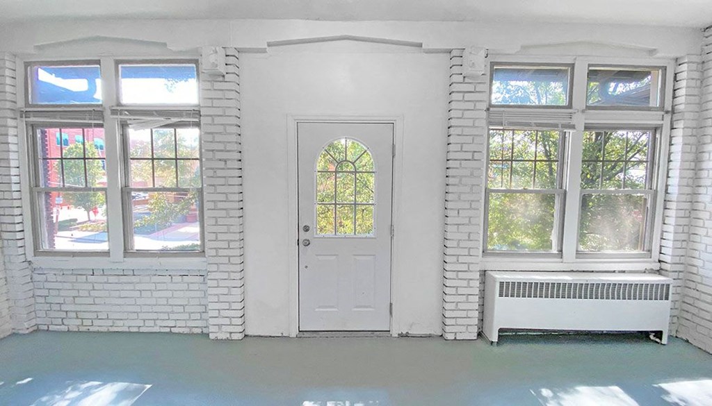 a room with a white door and two windows