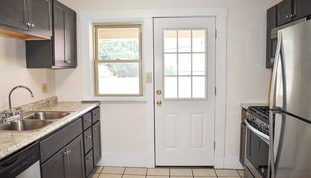 a kitchen with a sink a stove and a door