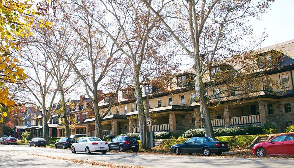 a row of apartment buildings with cars parked in front of them