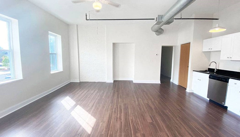 an empty kitchen and living room with hardwood floors