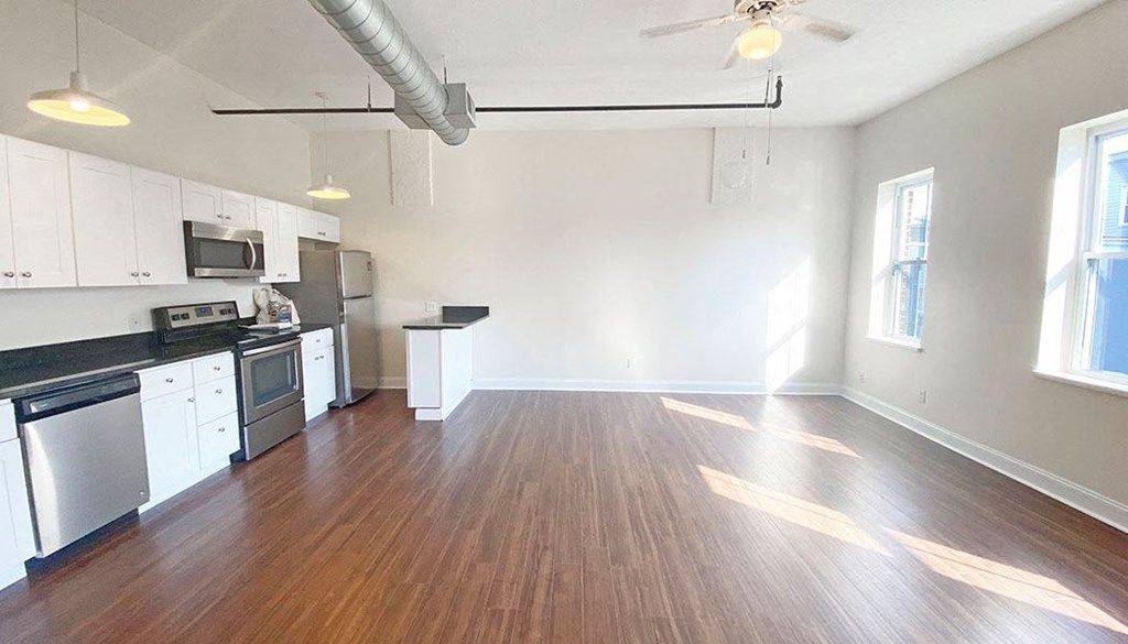 an empty kitchen and living room with hardwood floors