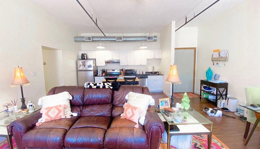 a living room with a leather couch and a glass coffee table