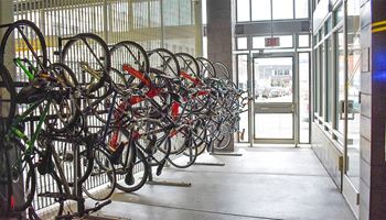 a bike rack filled with lots of bikes next to a building