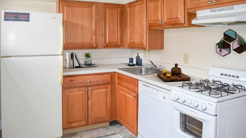 a kitchen with white appliances and wooden cabinets