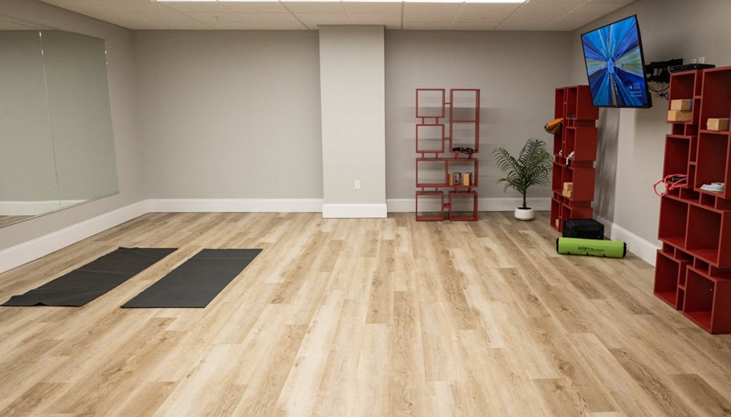 a rejuvenating yoga studio with light wood floors and a flat screen tv at The Washington at Chatham, Pennsylvania