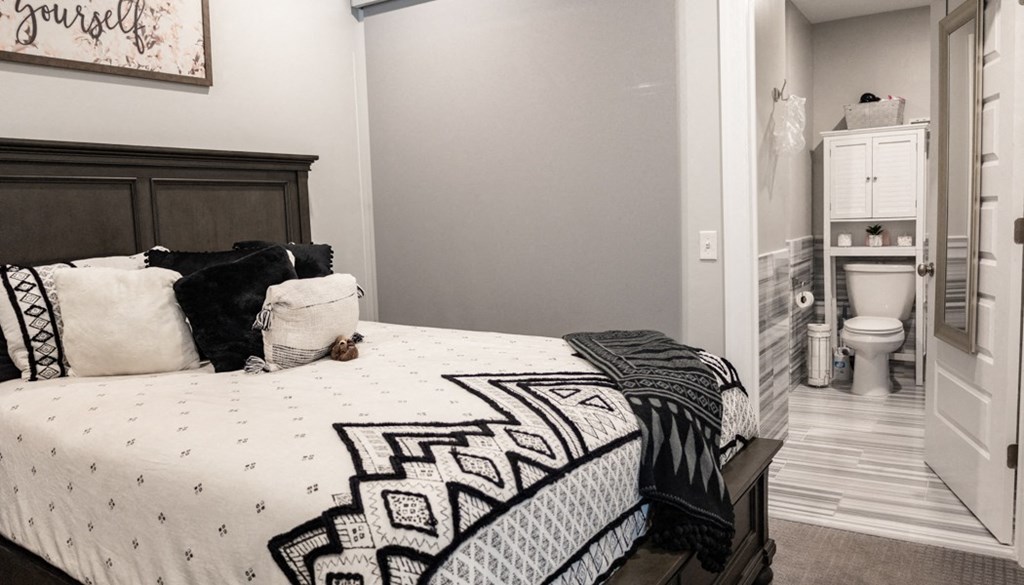 a bedroom with a bed and a bathroom in the background at The Washington at Chatham, Pittsburgh, PA 15219