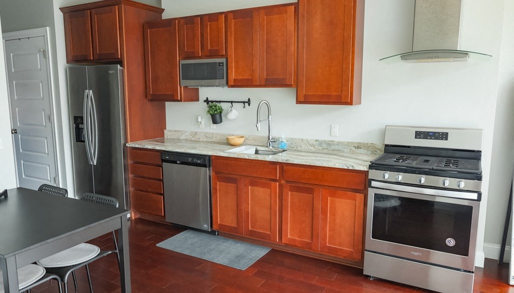 a kitchen with wood cabinets and stainless steel appliances at The Washington at Chatham, Pennsylvania, 15219