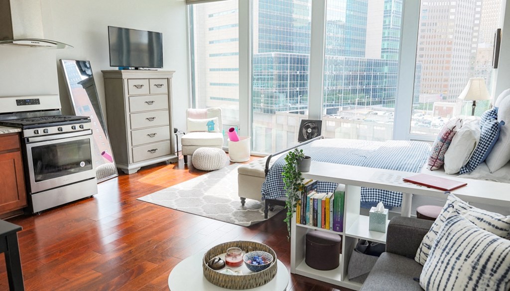 a small living room with a bed and a television in front of a large window at The Washington at Chatham, Pennsylvania