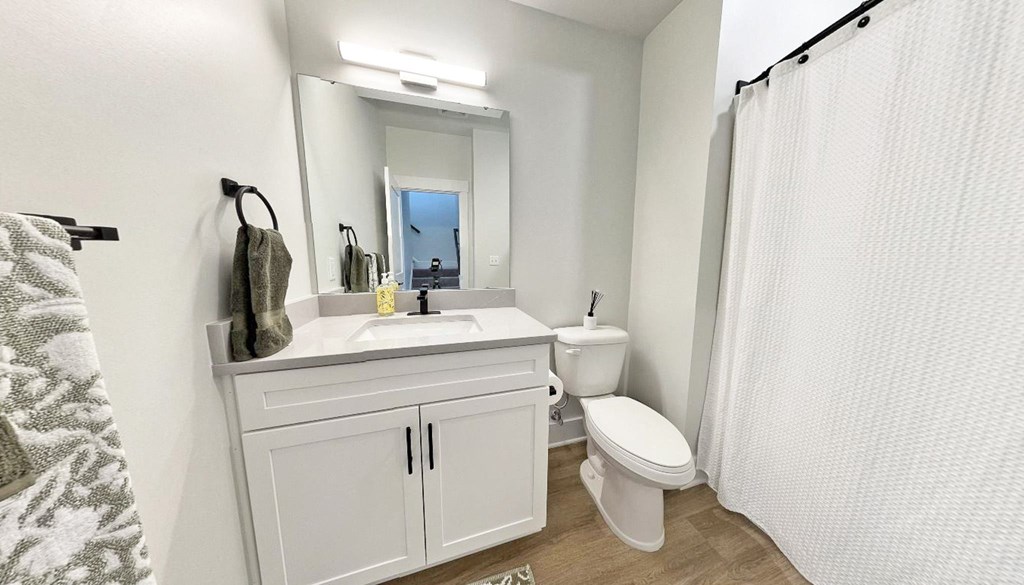 a bathroom with a sink toilet and a mirror