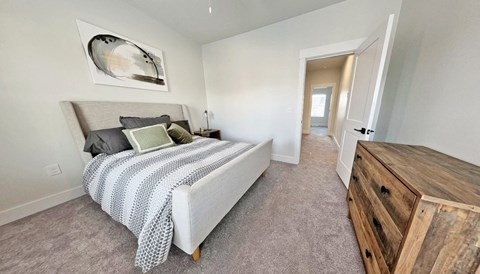 a bedroom with a bed and a wooden dresser