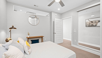 a bedroom with grey walls and a white bed at The Washington at Chatham, Pittsburgh, PA