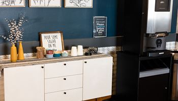 a kitchen with white cabinets and a blue wall