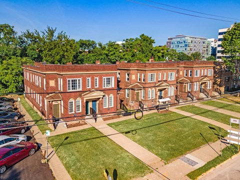 a large brick building with a grassy area in front of it at University Commons Apartments, Oakland, Pittsburgh