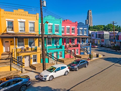 a row of colorful buildings on a city street at University Commons Apartments, Oakland, Pittsburgh
