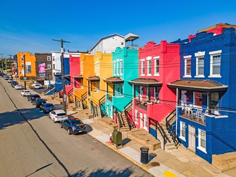 a row of colorful buildings on a city street at University Commons Apartments, Oakland, Pittsburgh
