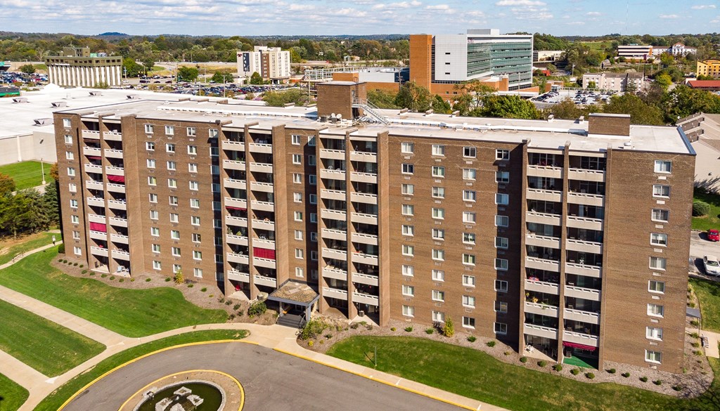a large apartment building with many balconies and a parking lot in front of it