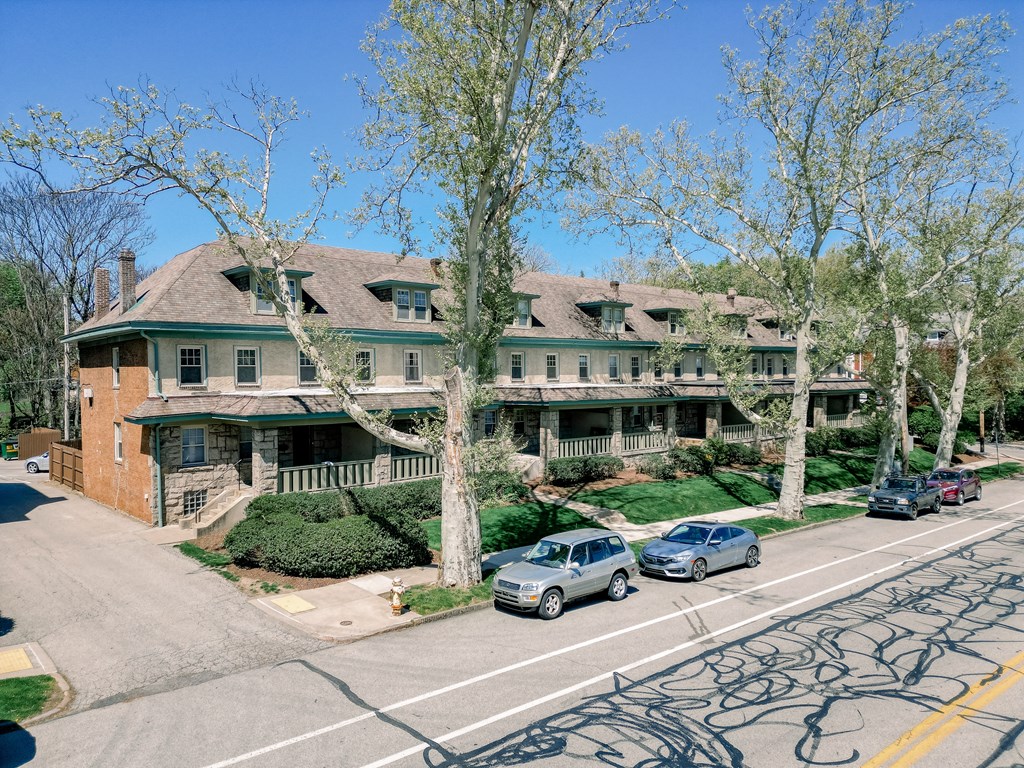 A street view of a residential area with houses and parked cars.