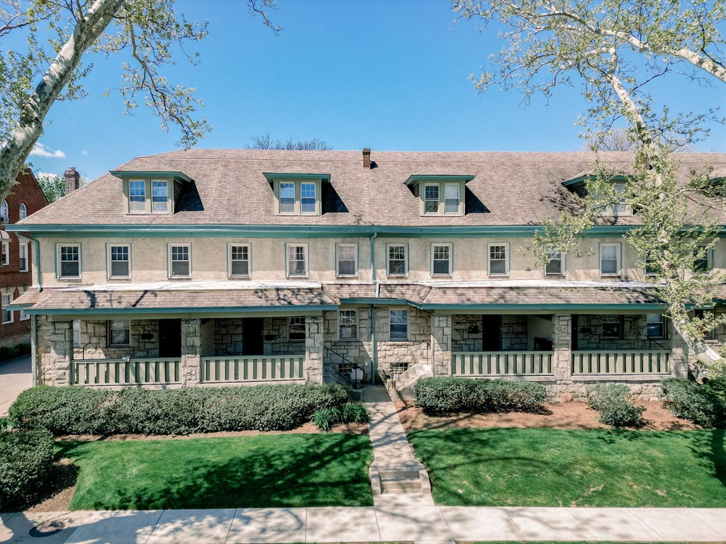 A large, two-story house with a green lawn in front.