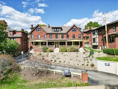 A large red brick building with a green lawn in front.