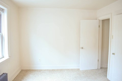 A white room with a carpeted floor and two doors.