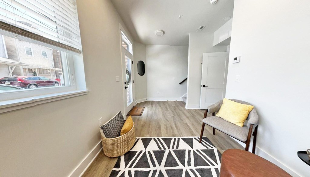 a living room with a couch and a chair next to a window