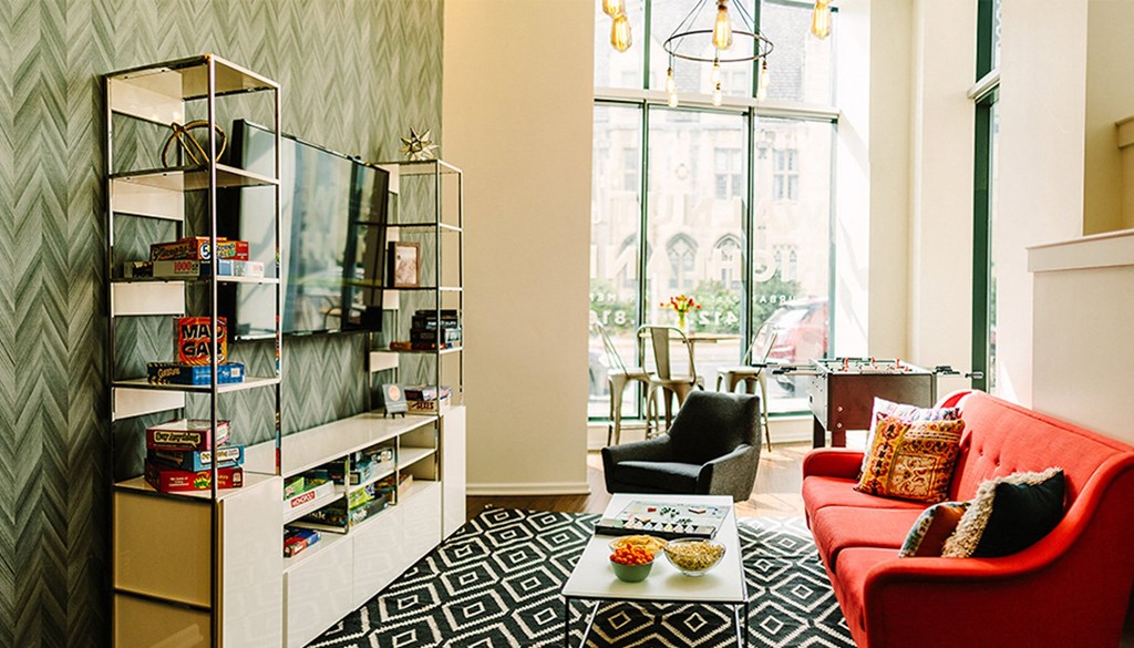 a living room with a red couch and black and white rug at Walnut on Highland, Pittsburgh, PA