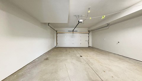 a large room with white walls and a white garage door