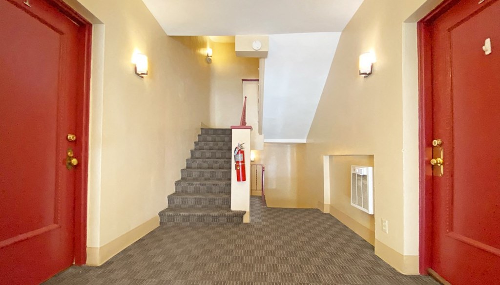a view down the stairs of the lobby and staircase to the rooms on the ground floor