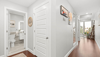 a hallway with a white door and hardwood floors at The Washington at Chatham, Pittsburgh Pennsylvania