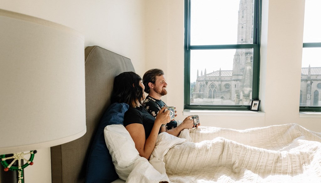 a couple sits in bed at Walnut on Highland, Pittsburgh, PA