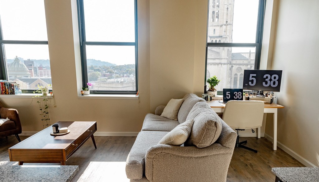 a living room with a couch and a table in front of a window at Walnut on Highland, Pittsburgh, PA