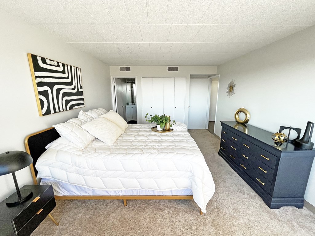 a bedroom with a large white bed and a black dresser at Walnut Towers at Frick Park, Pittsburgh
