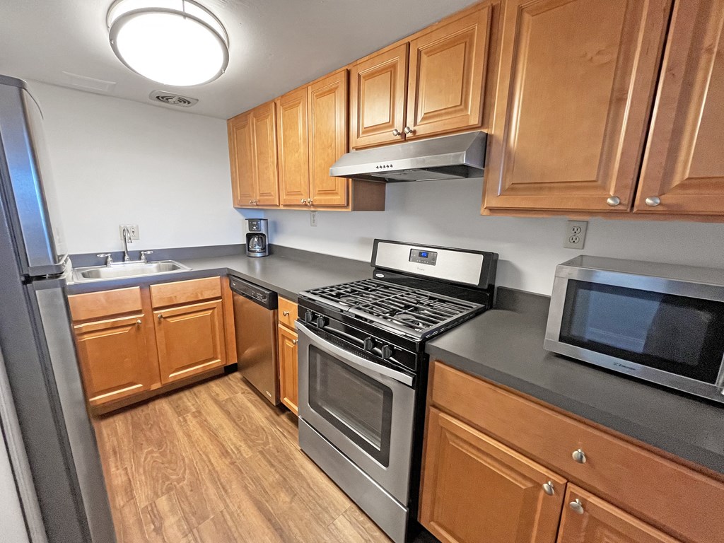 A kitchen with wooden cabinets and stainless steel appliances at Walnut Towers at Frick Park, Pittsburgh, 15217