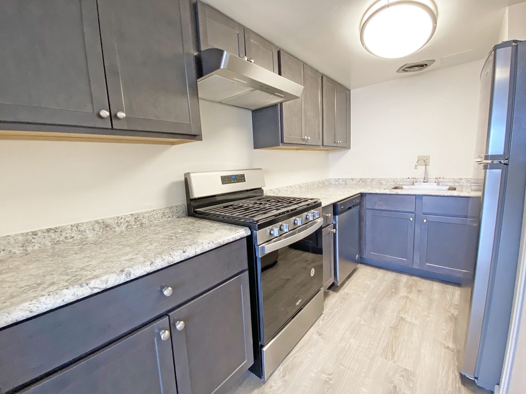 A kitchen with a stove top oven and a refrigerator at Walnut Towers at Frick Park, Pennsylvania