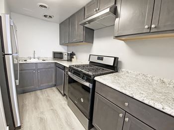 A kitchen with a refrigerator, microwave, oven, and sink at Walnut Towers at Frick Park, Pittsburgh, Pennsylvania