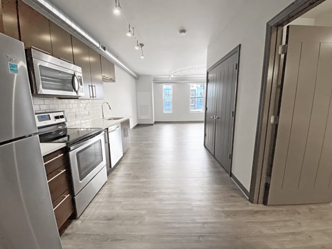 A kitchen with a refrigerator, oven, and microwave.