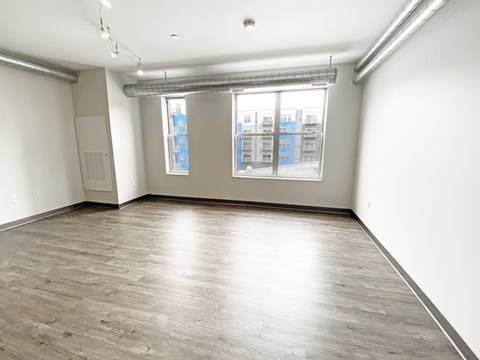 A room with a window and a wooden floor.