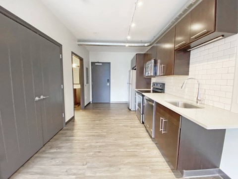 A kitchen with a sink and a refrigerator.