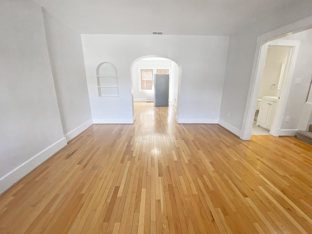 A room with wooden flooring and white walls.