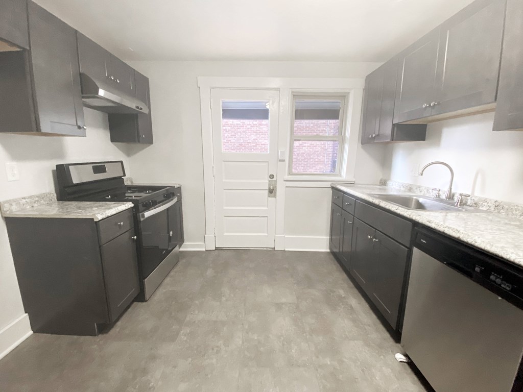 A kitchen with black appliances and cabinets.