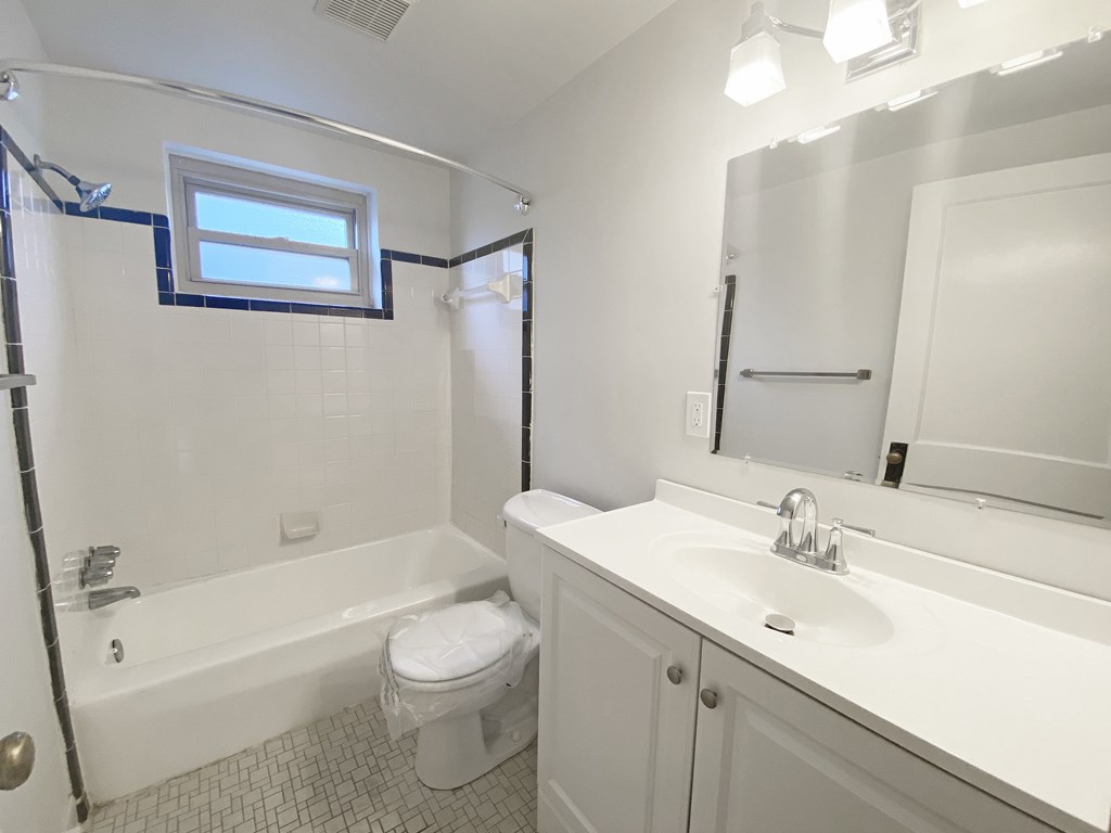A white bathroom with a toilet, sink, and bathtub.