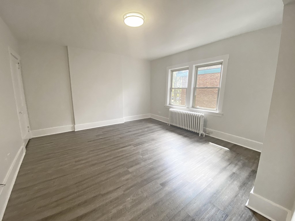 A room with a window and a radiator on the wall.
