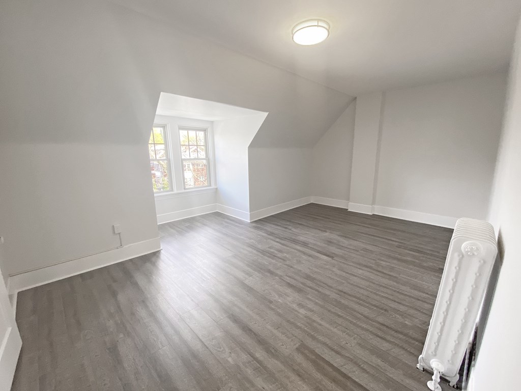 A room with a window and a radiator on the wall.