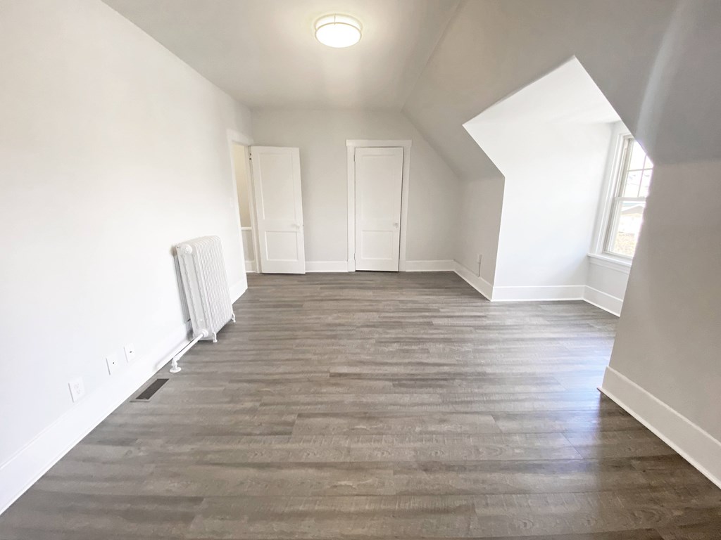 A room with wood flooring and white walls.