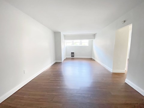 A room with wooden flooring and white walls.