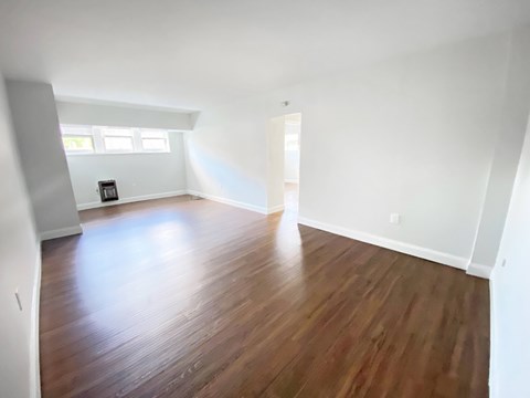 A room with wooden flooring and white walls.