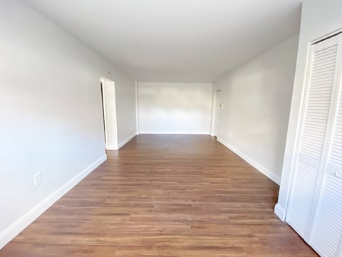 A long hallway with wooden floors and white walls.