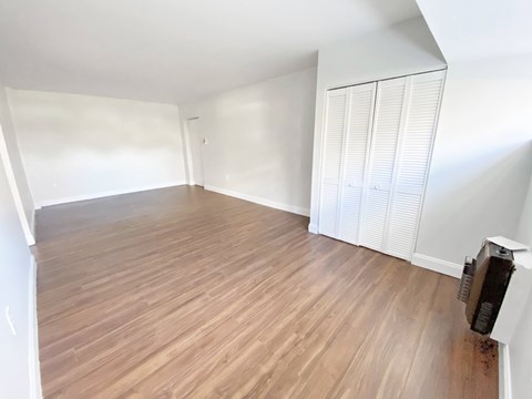 A room with wooden flooring and white walls.