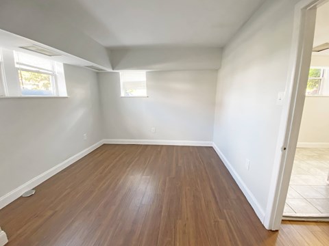 A room with wooden flooring and white walls.